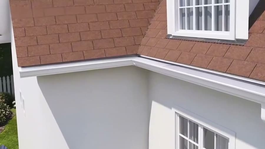 A house corner photographed from the air: the roofline, the gutter run along the eave and the return around the corner