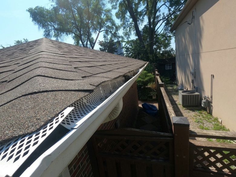 A clip-on gutter cover lifting away from the gutter it was fitted to